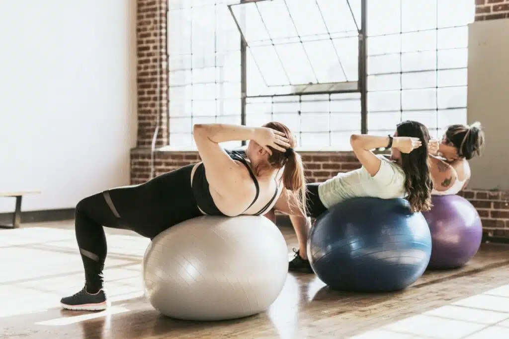 Kobiety ćwiczące mięśnie brzucha z piłką fitness