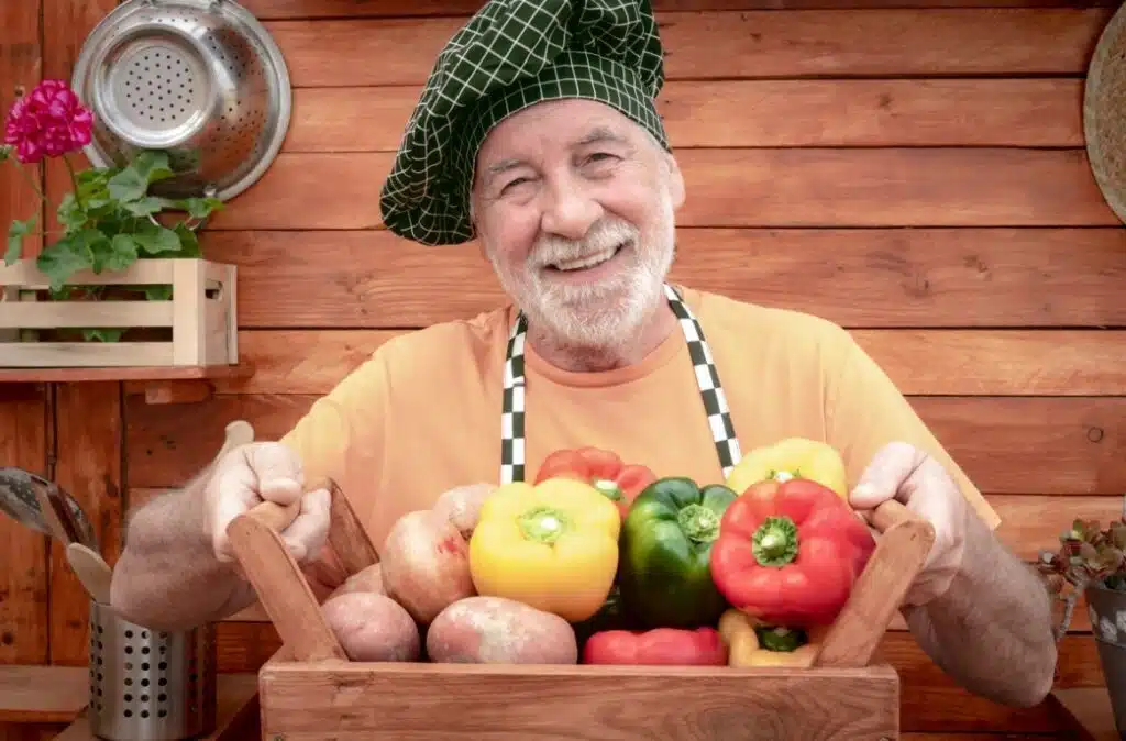 Starszy pan trzymający koszyk z warzywami 
