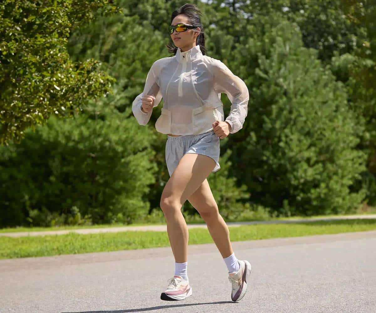  Kobieta biegnąca przez park w butach New Balance Rebel V5